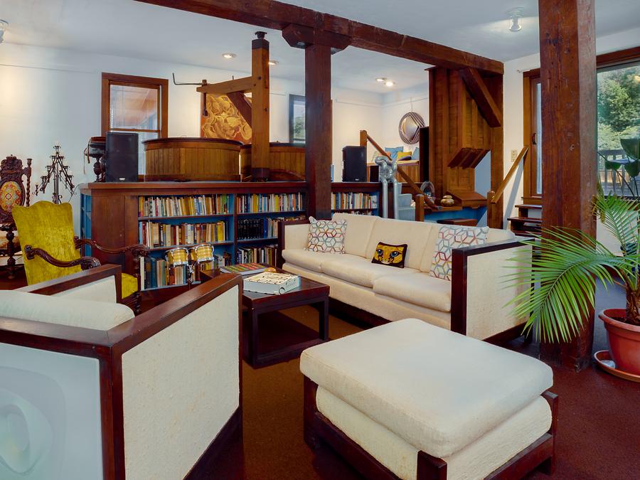 The gallery living room — low sofas, bookshelves, and artwork on the walls