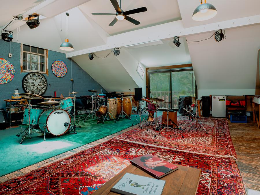 The third-floor jam room — drum kit, amps, and instruments on a patterned rug