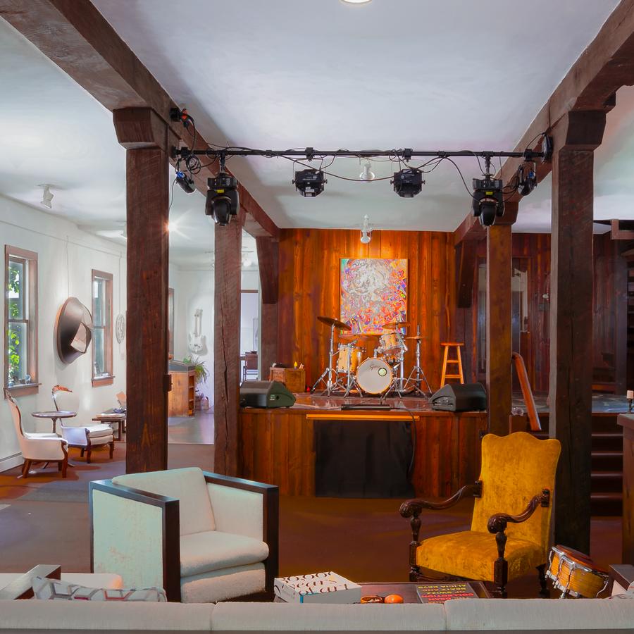 The gallery stage set with a drum kit, framed by the mill's original timber posts