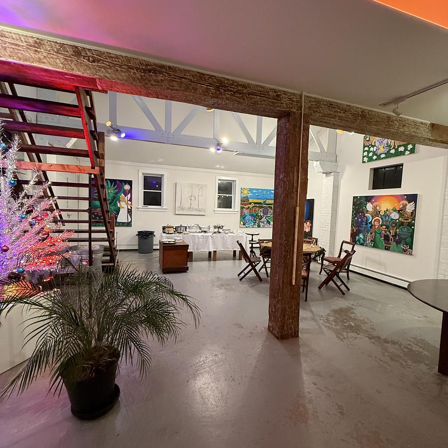 The upper gallery and loft stair, artwork hung along the white walls